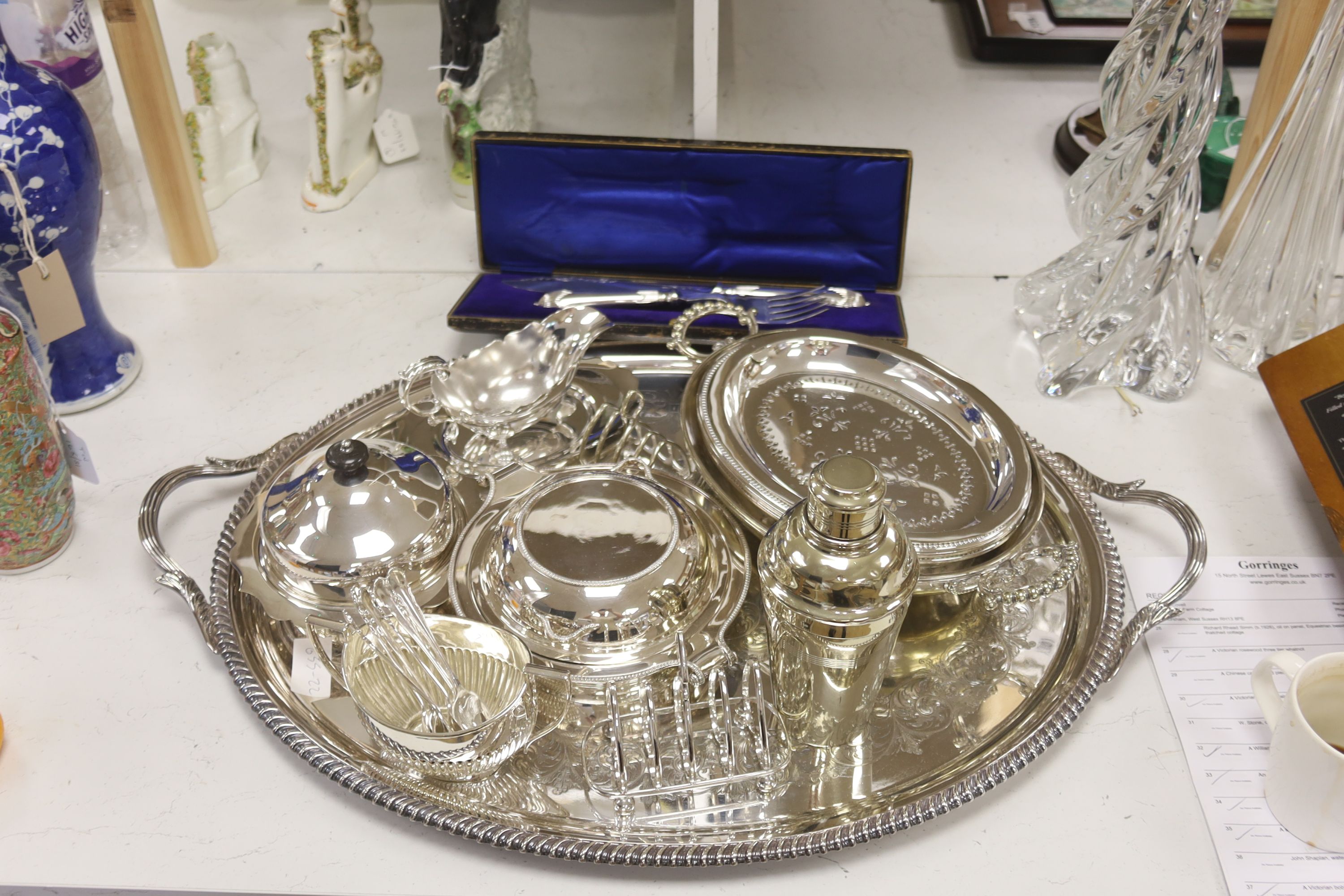 A collection of silver-plated wares to include an oval drinks tray, a cocktail shaker, serving tureens, etc.